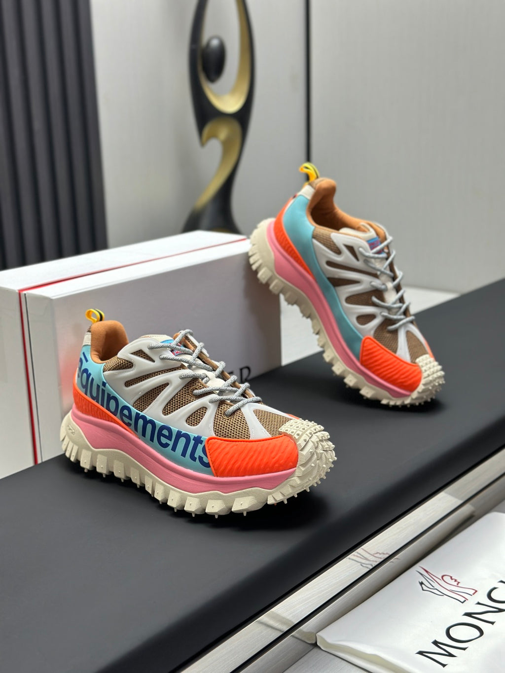 Moncler trail sneaker pair, white upper with orange and pink side panels and chunky tread