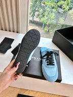 Prada women's light blue sneakers with black lace-up design and textured rubber outsole