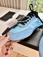 Prada women's light blue lace-up sneaker with black laces and Prada tongue tag