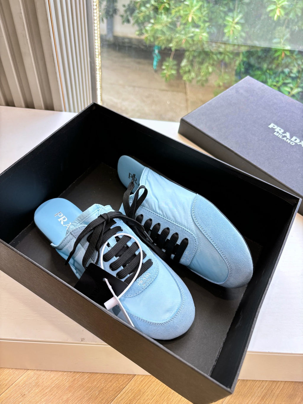 Prada women's light blue lace-up sneakers with black laces, front pair view