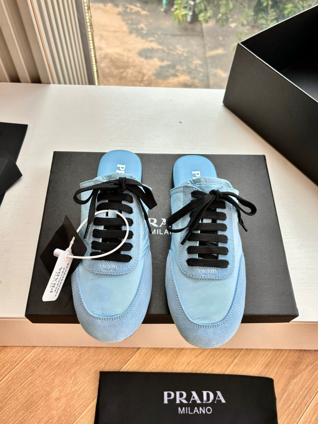 Prada women's light blue lace-up sneakers with black laces and stitched toe cap