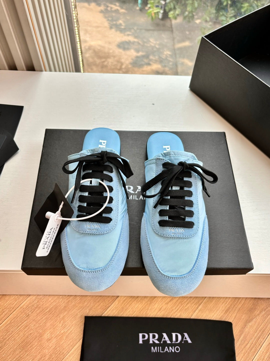 Prada women's light blue lace-up sneakers with black laces and stitched toe cap