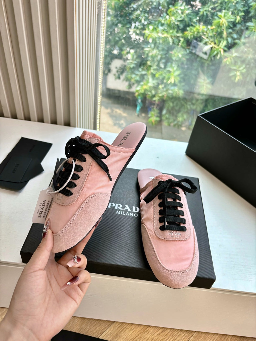 Prada lace-up sneakers for women, pink suede shoe held up with matching pair in box