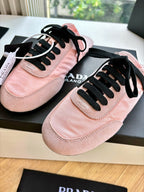 Prada lace-up sneakers for women, pink suede close-up with black laces and stitched toe