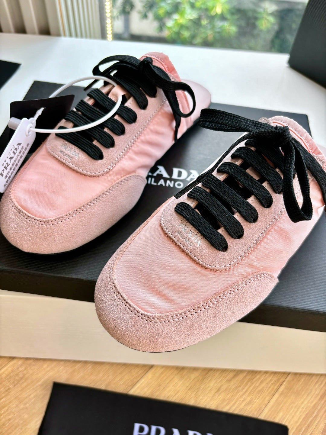 Prada lace-up sneakers for women, pink suede close-up with black laces and stitched toe