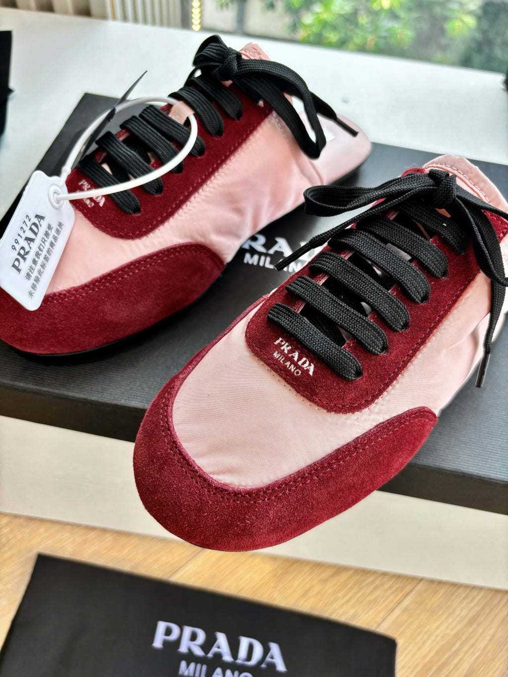 Prada women's sneakers close-up, blush pink and burgundy with black laces
