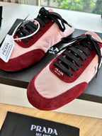 Prada women's sneakers close-up, blush pink and burgundy with black laces