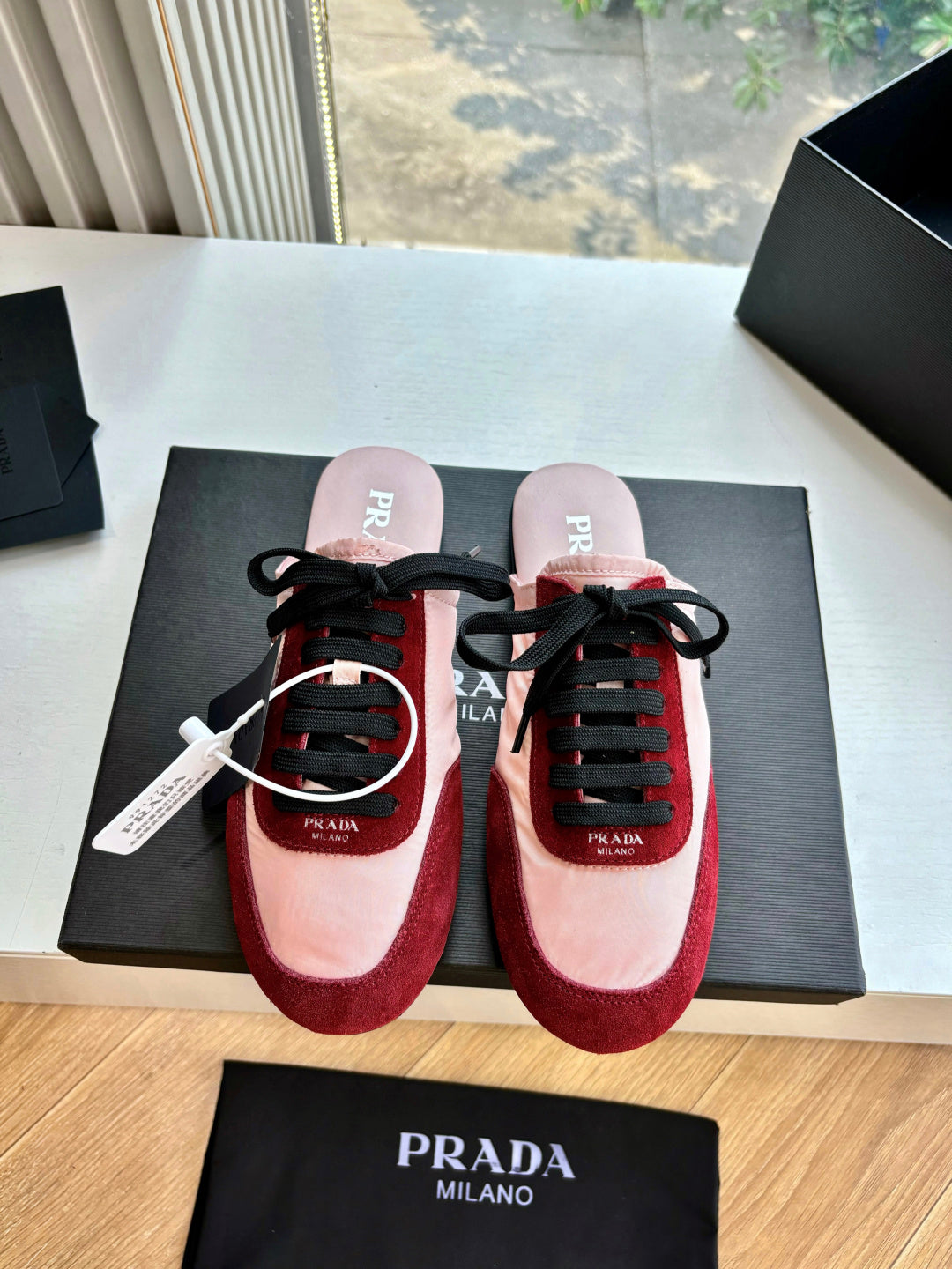 Prada women's sneakers pair, blush pink uppers with burgundy suede and black laces