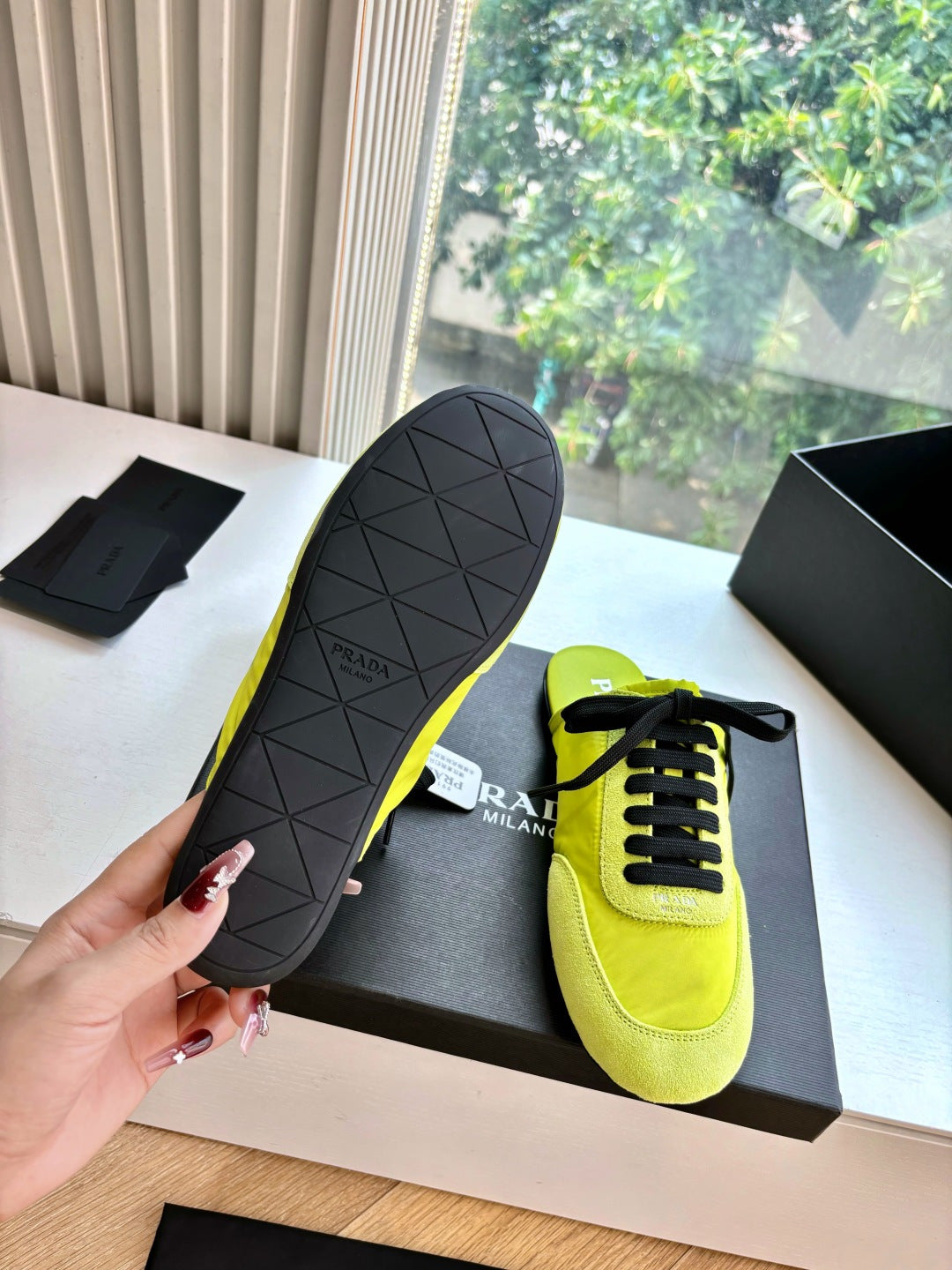 Neon yellow lace-up sneakers with dark rubber outsole, Prada logo on side and sole