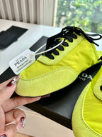 Neon yellow lace-up sneaker close-up with black laces, toe panel stitching