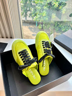Neon yellow lace-up sneakers on black box, black laces and Prada logo detail