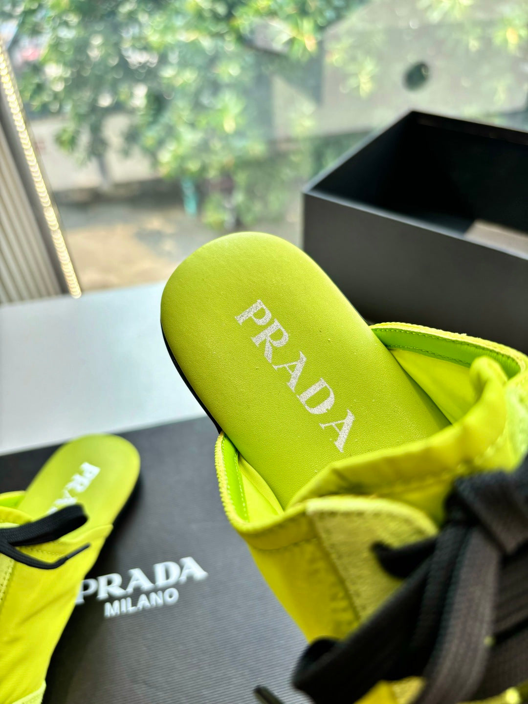 Neon yellow sneaker slide view showing PRADA insole and inner heel lining