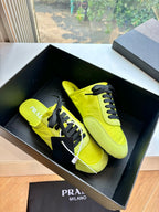 Neon yellow lace-up sneakers with black lace eyelets and side logo, inside box view