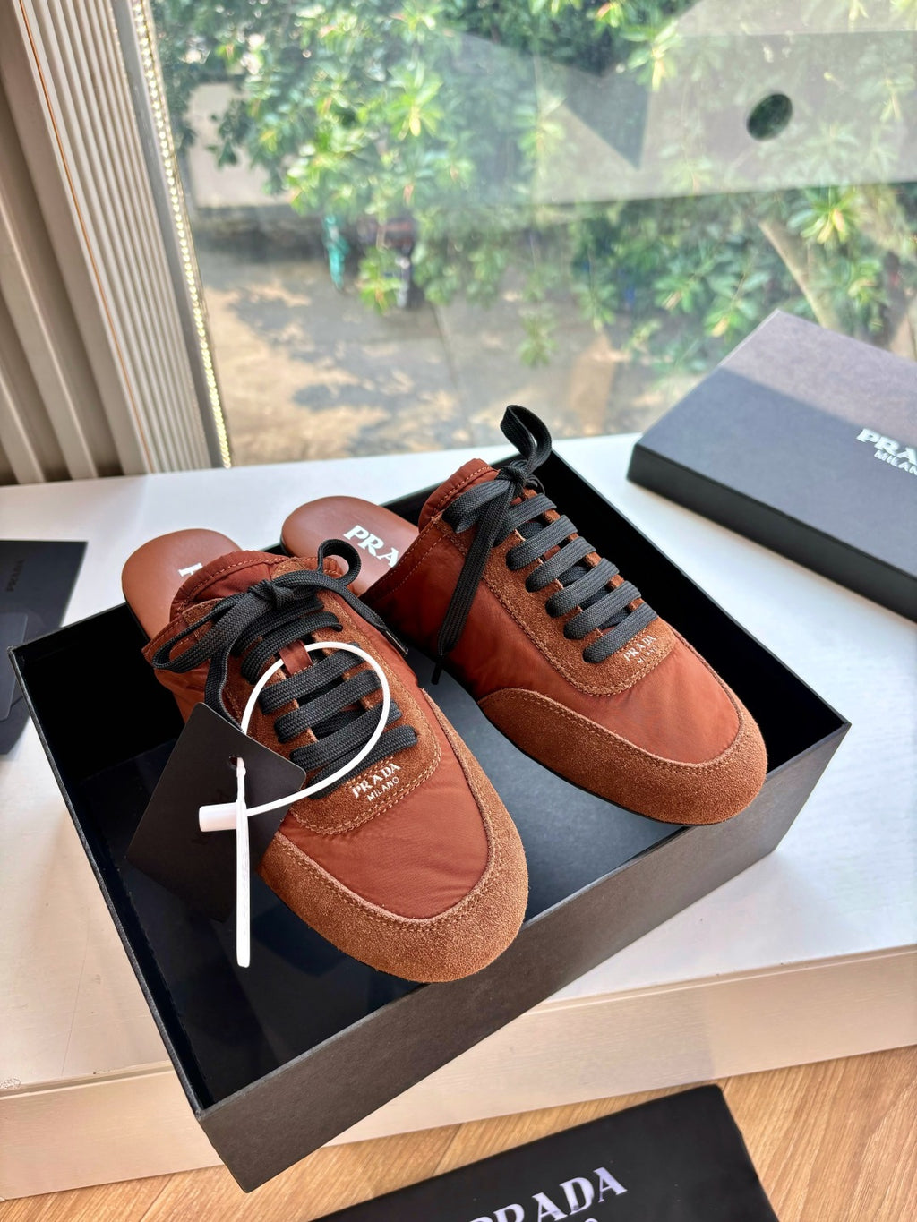 Prada low-top sneakers in tan suede with black laces and round toe