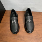 Prada unisex black leather loafers, front view with strap and Prada logo on uppers