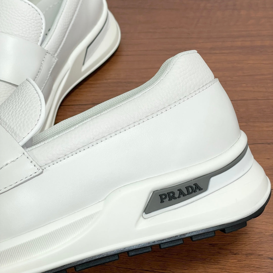 Close-up of white Prada unisex slip-on sneaker side logo on sole