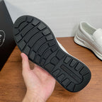Black tread outsole of white Prada unisex slip-on sneakers