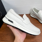 White Prada unisex slip-on sneaker held up, side logo and thick sole