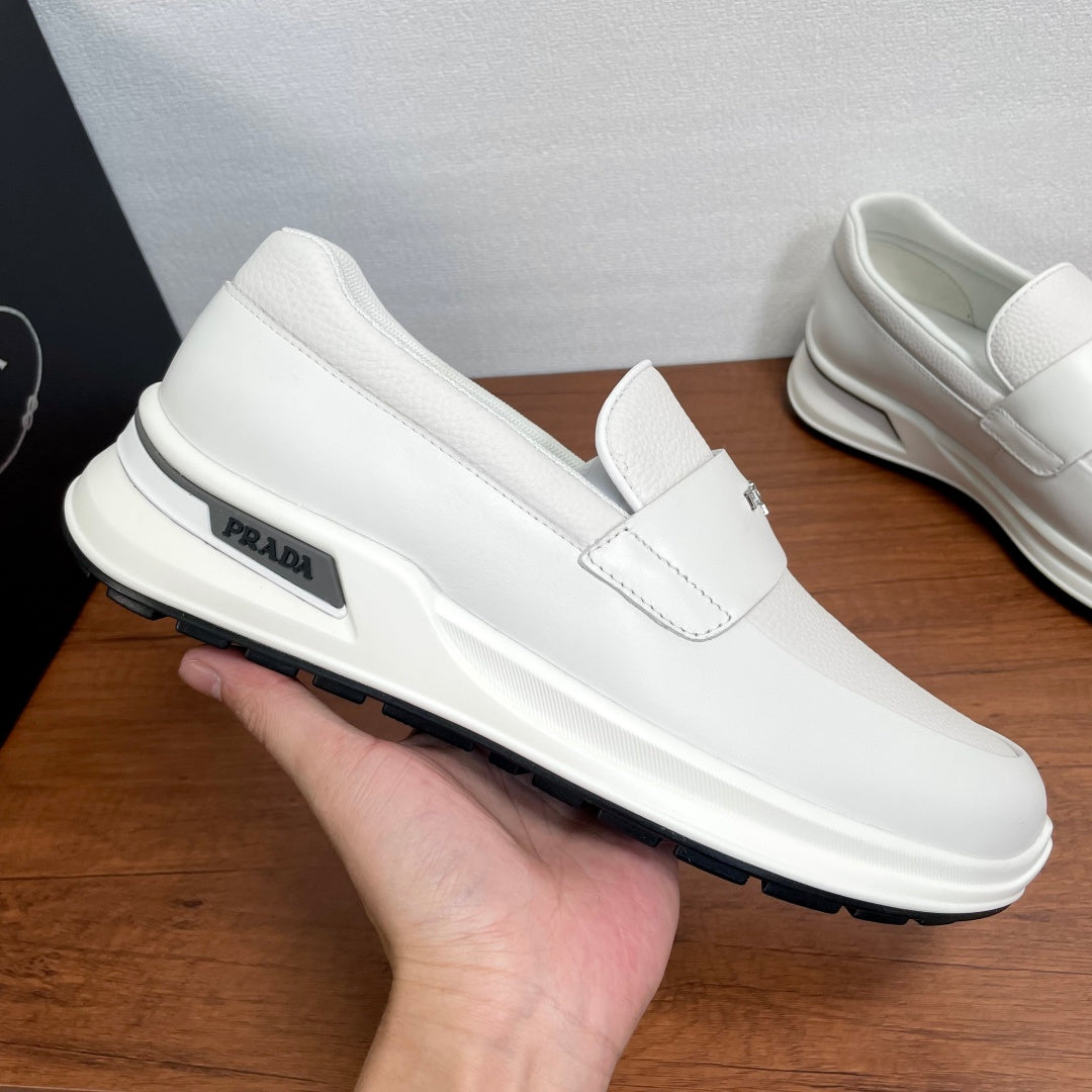 White Prada unisex slip-on sneaker held up, side logo and thick sole