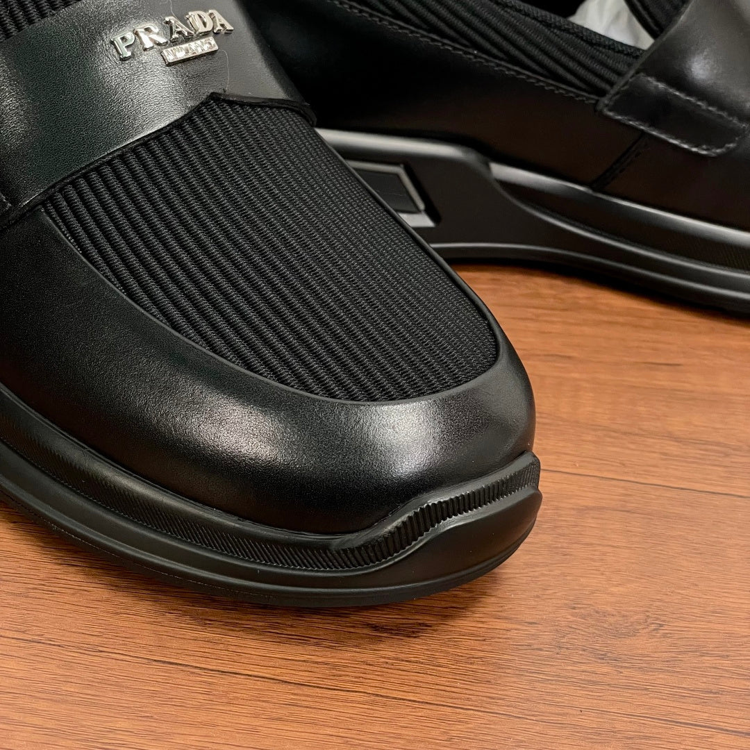 Prada unisex loafers toe close-up, black leather slip-on with ribbed elastic and rubber edge