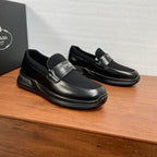 Prada unisex loafers, black leather slip-ons with metallic logo buckle and chunky sole