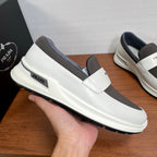 White slip-on sneakers with gray elastic panels and Prada label on side