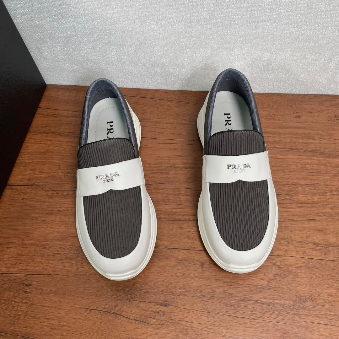 White slip-on sneakers with gray elastic insets and Prada branding on strap