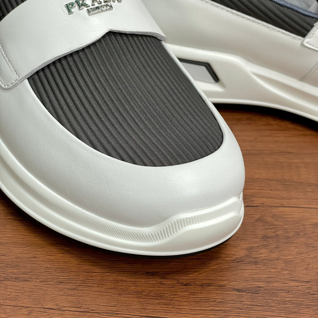 Close-up of white slip-on sneaker toe with gray elastic insert and logo
