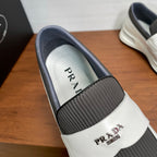 White slip-on sneakers with gray collar and PRADA on insole