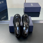 Black leather unisex loafer pair facing front with Dior logo buckle