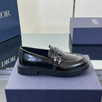 Black leather unisex loafer on box base, front strap buckle and low tread sole