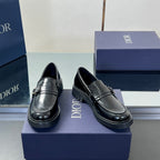 Pair of black leather unisex loafers with stitched apron and front buckle detail