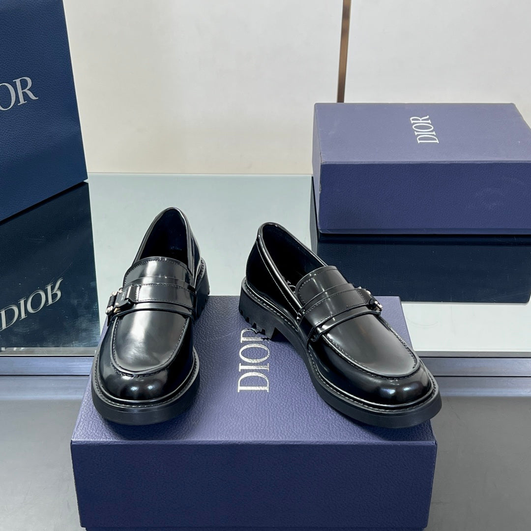 Pair of black leather unisex loafers with stitched apron and front buckle detail