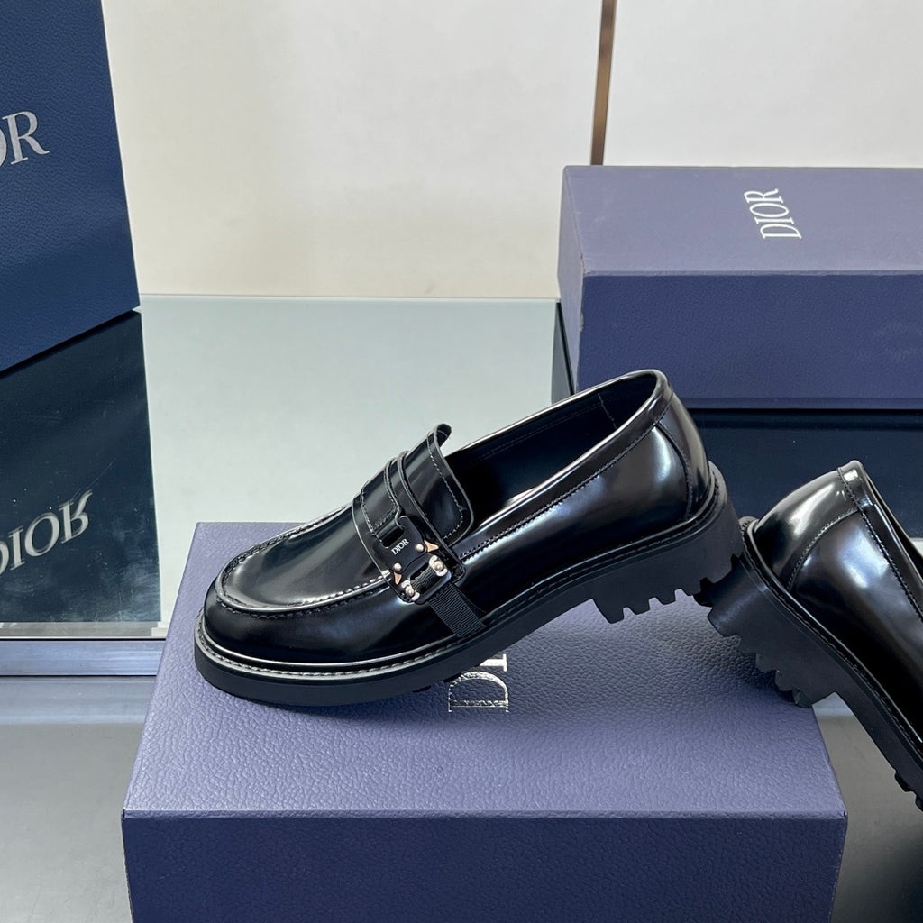 Black leather unisex loafers showing side profile, front strap buckle and tread sole