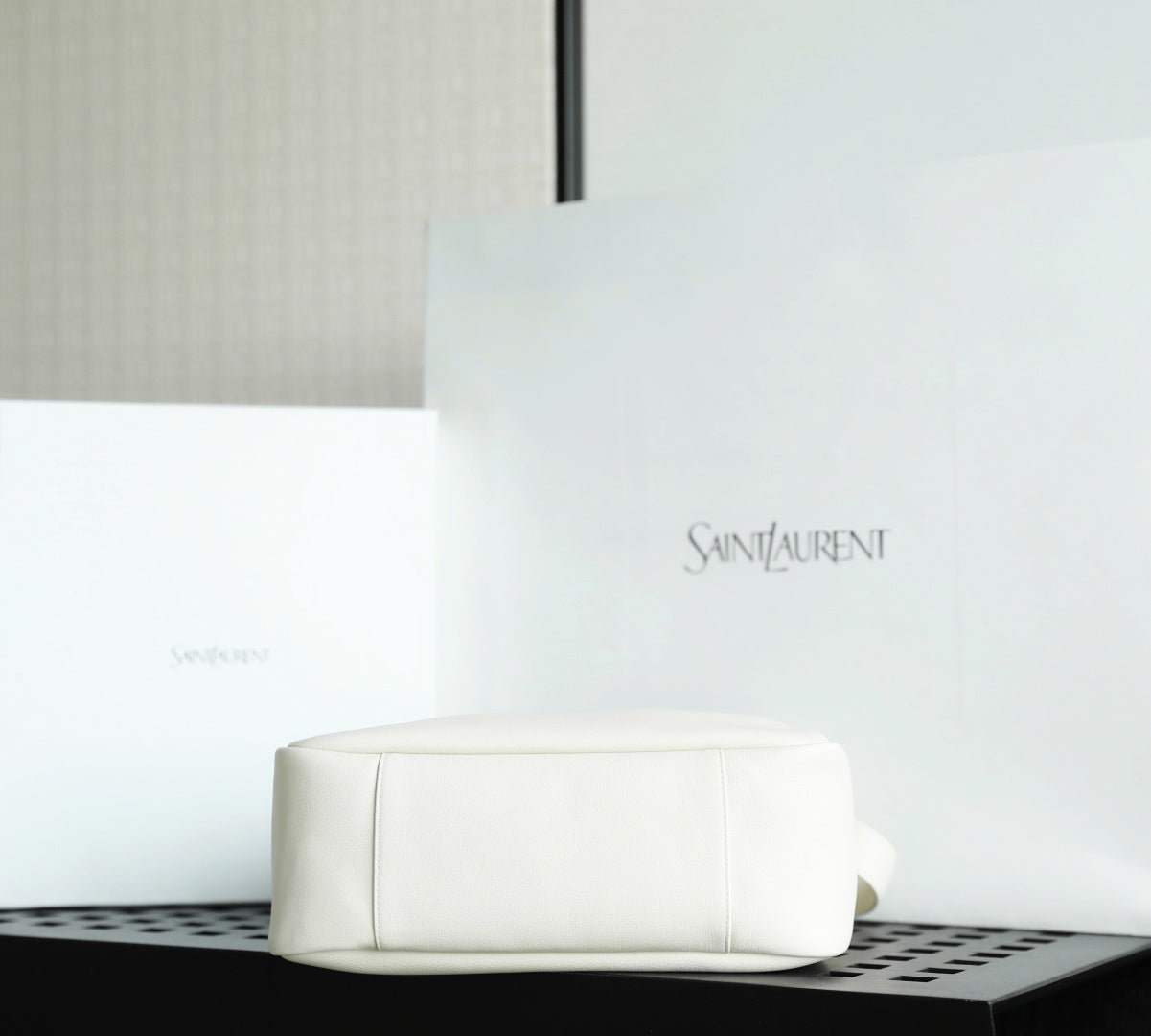 YSL bag white leather pouch style with embossed logo on front.