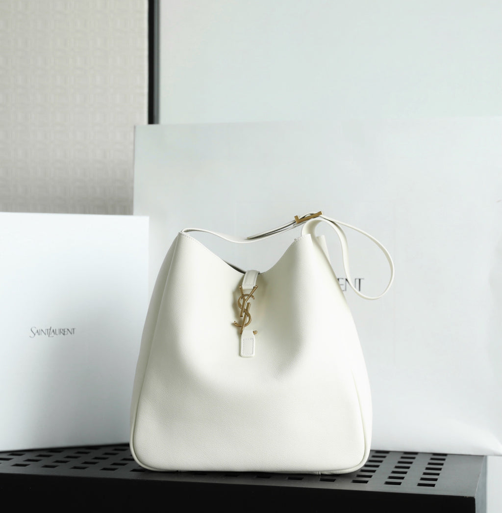 YSL bag in white leather with gold key-like clasp and loop handle.
