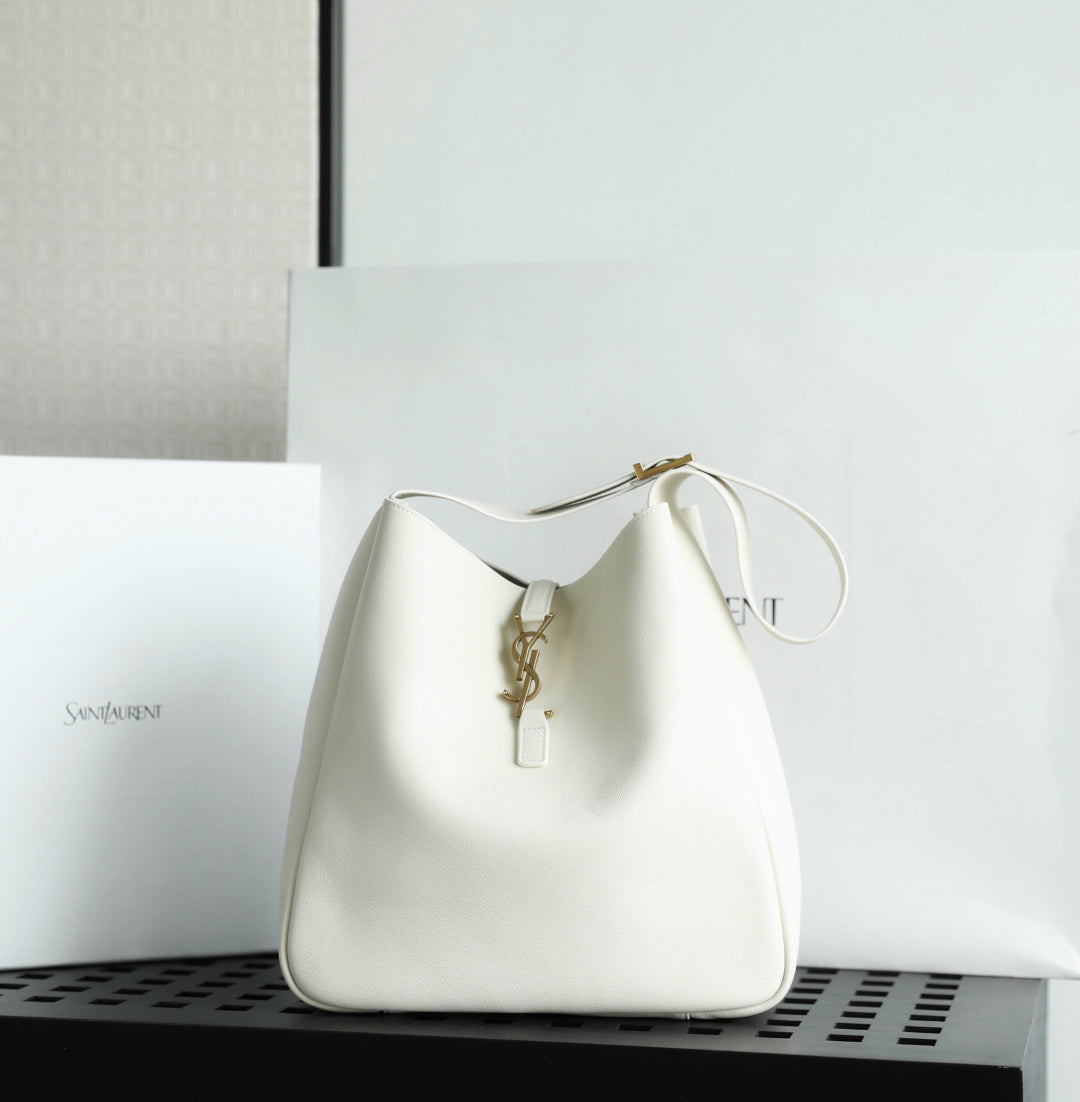 YSL bag in white leather with gold key-like clasp and loop handle.