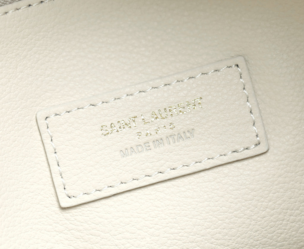 YSL bag white leather label with embossed branding and stitched border.