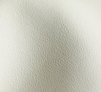 YSL bag white leather texture close-up, pebbled grain and stitching visible.