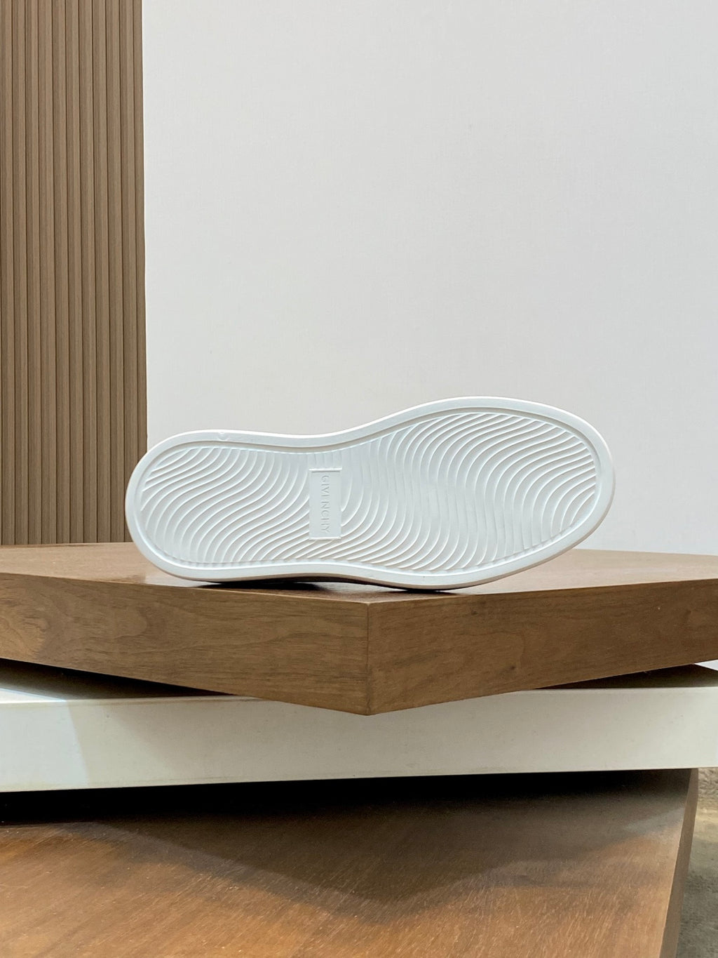 White sneaker outsole with textured tread pattern, viewed from below