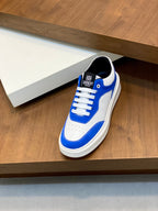 Blue and white low-top lace-up sneaker on display shelf, front three-quarter view
