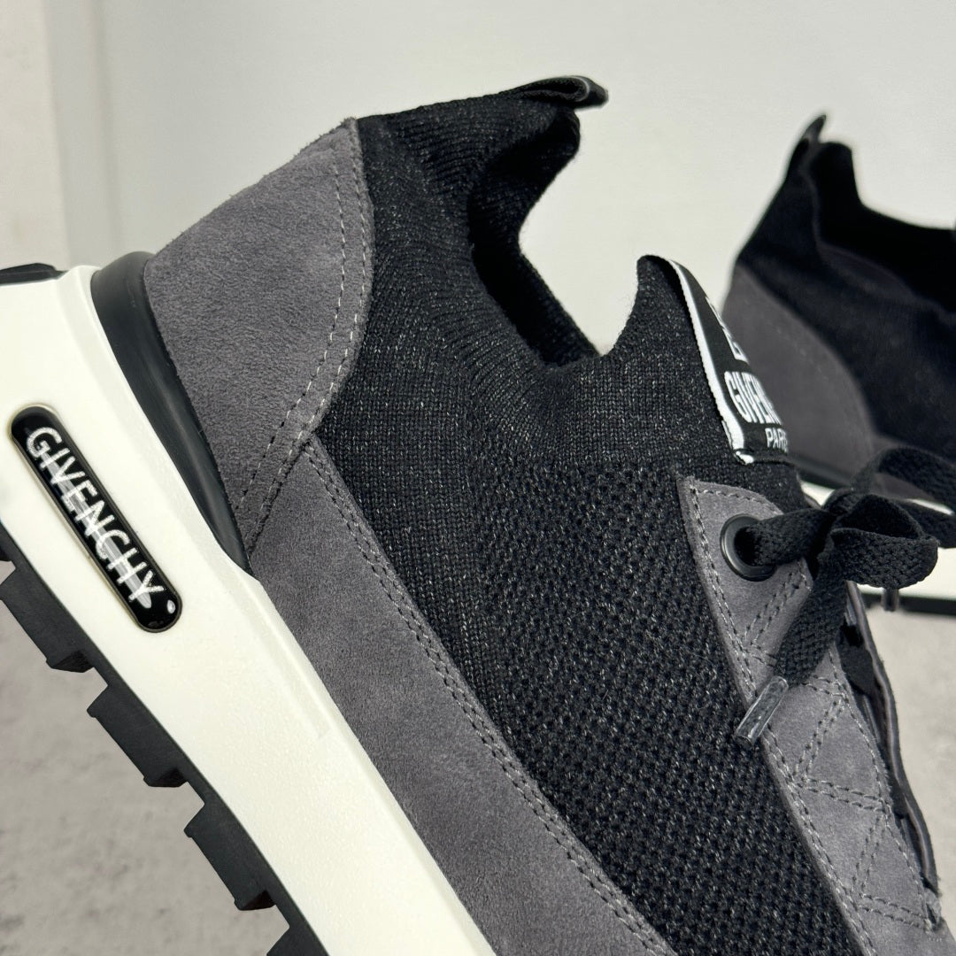 Close-up of black lace-up sneaker upper with dark gray trim and logo patch