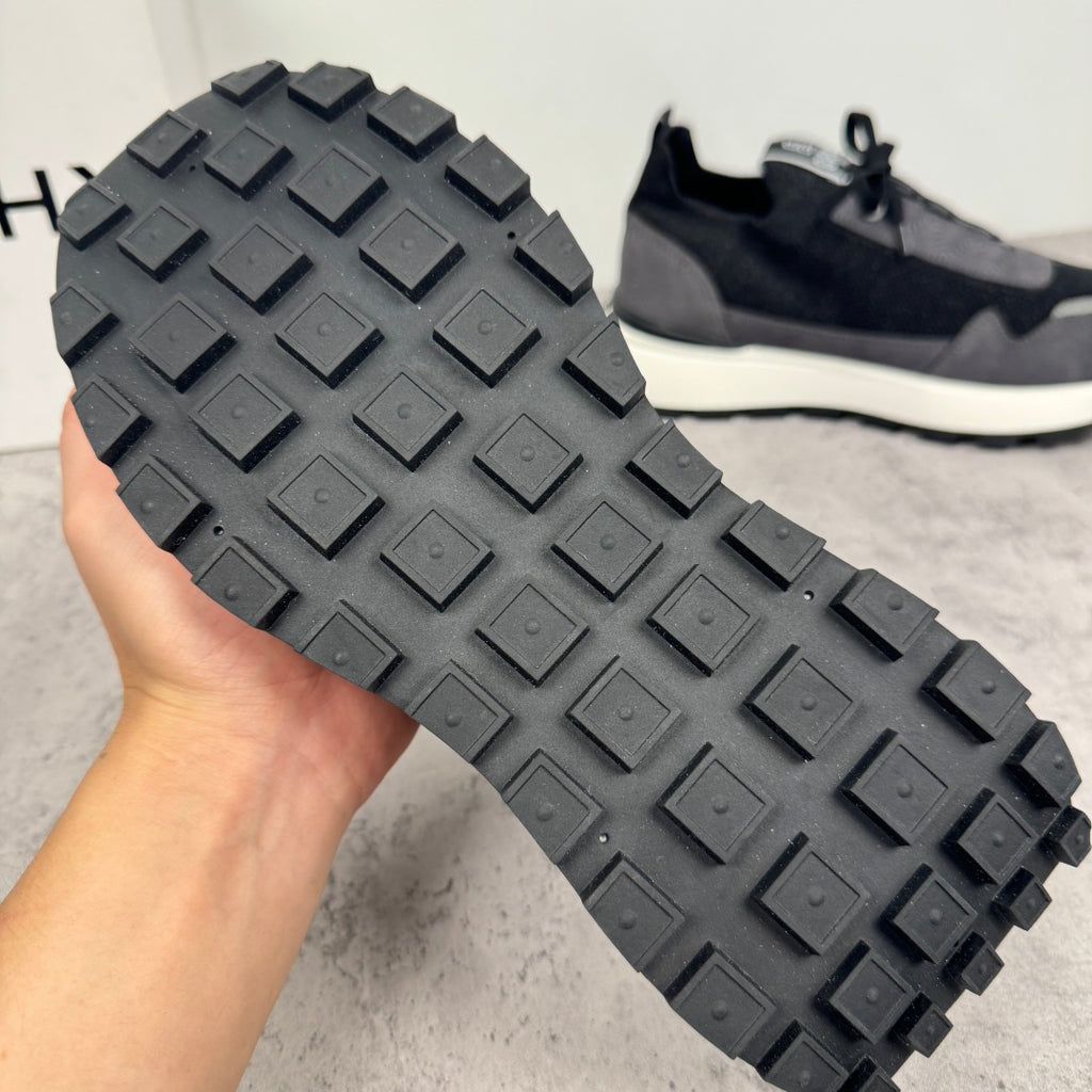 Black sneaker outsole with textured rubber tread, raised square pattern