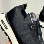 Black Givenchy sneakers with logo tongue patch, lace-up eyelets, and white sole
