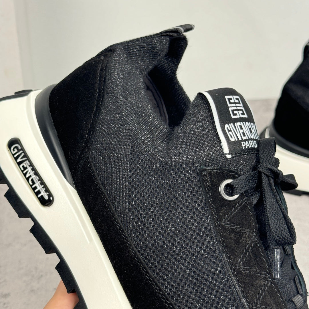 Black Givenchy sneakers with logo tongue patch, lace-up eyelets, and white sole