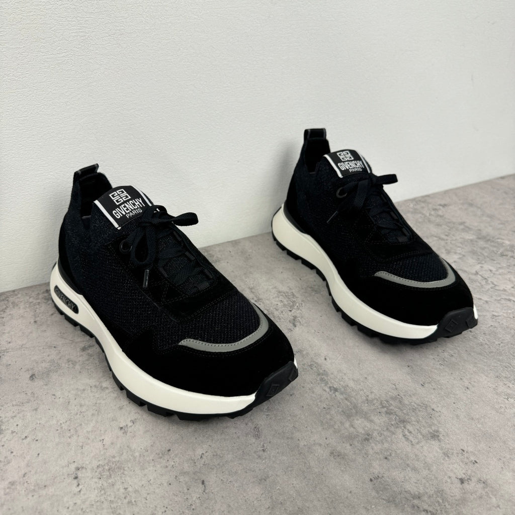 Black Givenchy low-top sneakers, side view with textured panels and white rubber sole