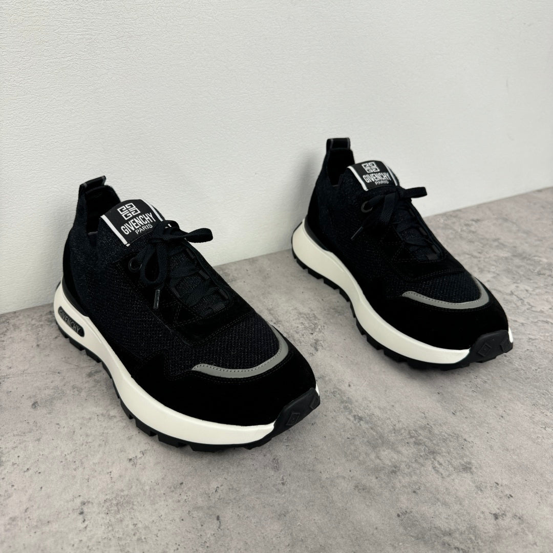 Black Givenchy low-top sneakers, side view with textured panels and white rubber sole
