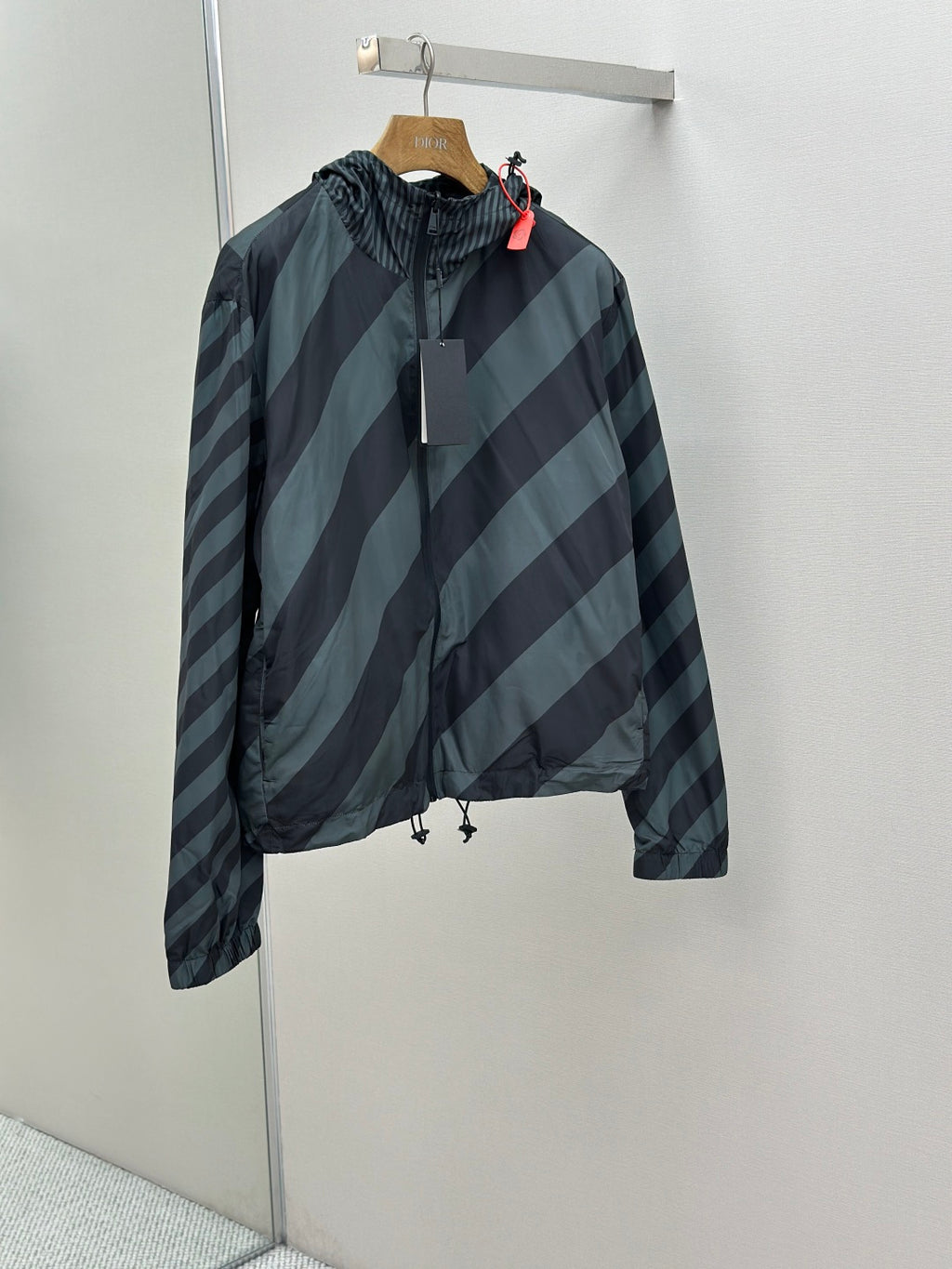 Hooded windbreaker jacket in dark blue and light blue diagonal striped pattern