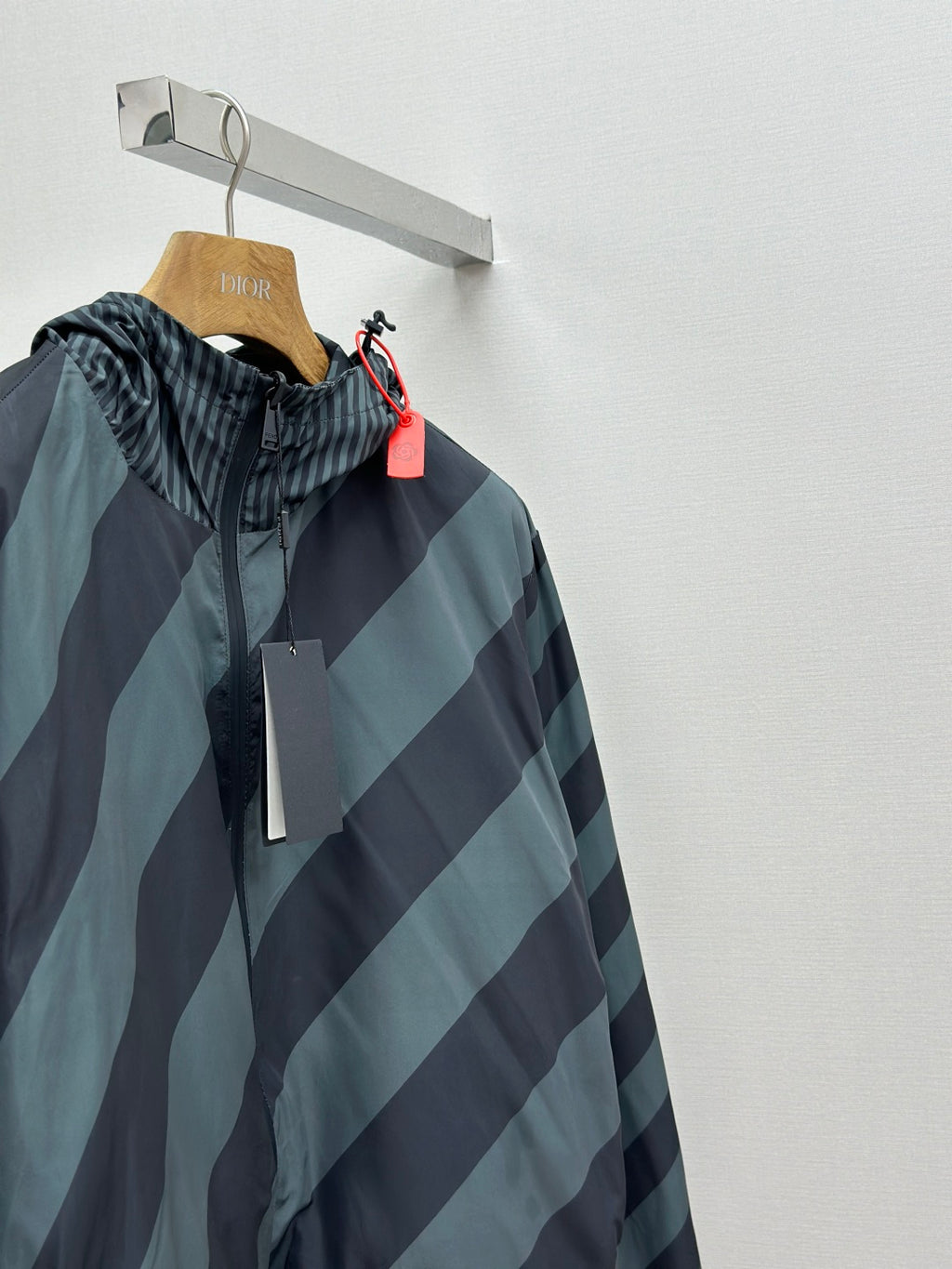 Hooded windbreaker jacket with diagonal stripes; full front view with zipper