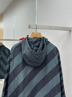 Hooded windbreaker jacket with diagonal stripes; close-up of hood and zipper